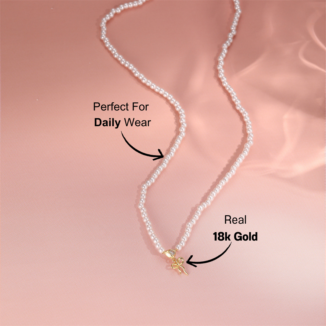 gold-pearl-necklace-pink-background.png – Sophisticated pearl necklace with a 14k gold bow charm, displayed on a soft pink background to highlight its delicate and feminine design.