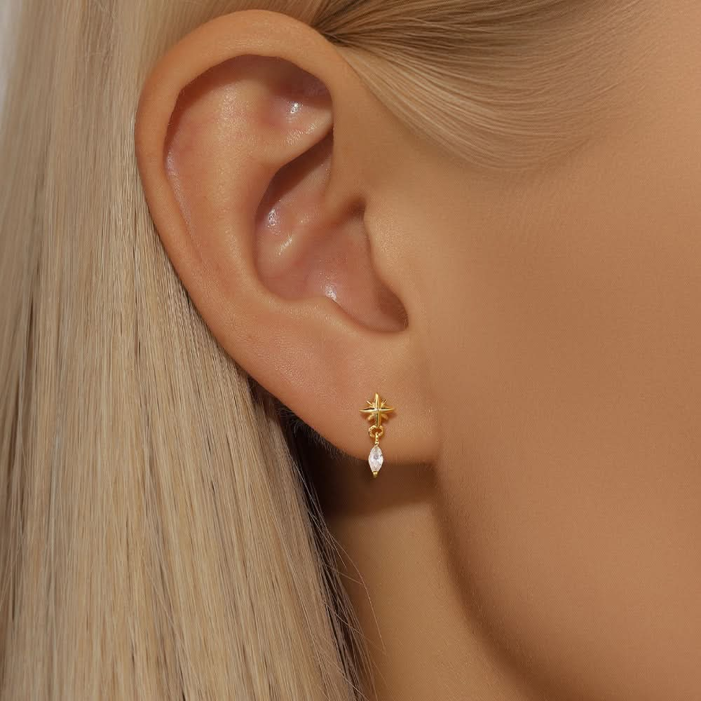 Model wearing golden star earrings with diamond drop, showcasing a subtle yet glamorous design.