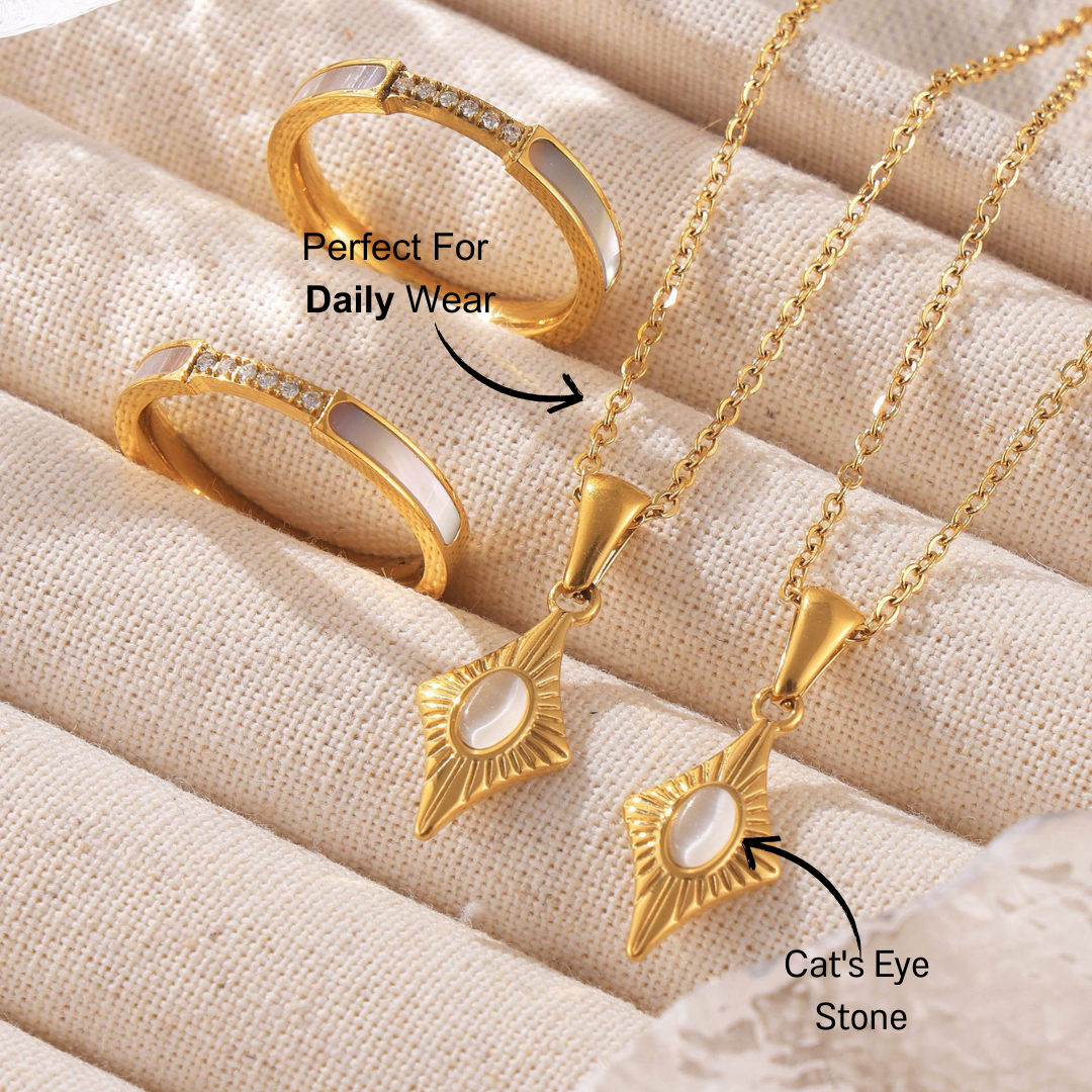 Close-up of layered 14k gold-plated titanium steel necklaces featuring a cat's eye stone four-corner star pendant.