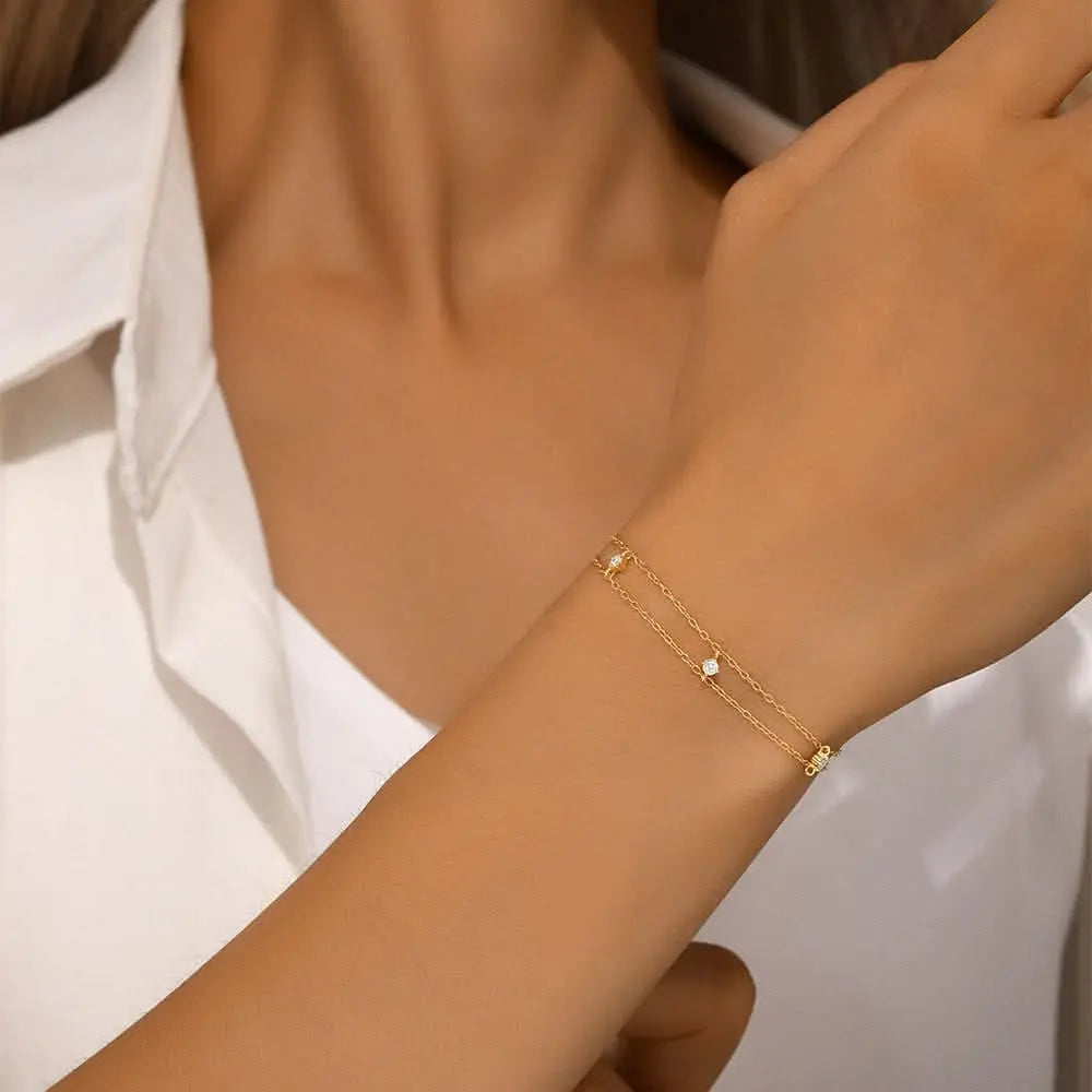 Minimalist gold bracelet with sparkling crystals and a stylish layered design.