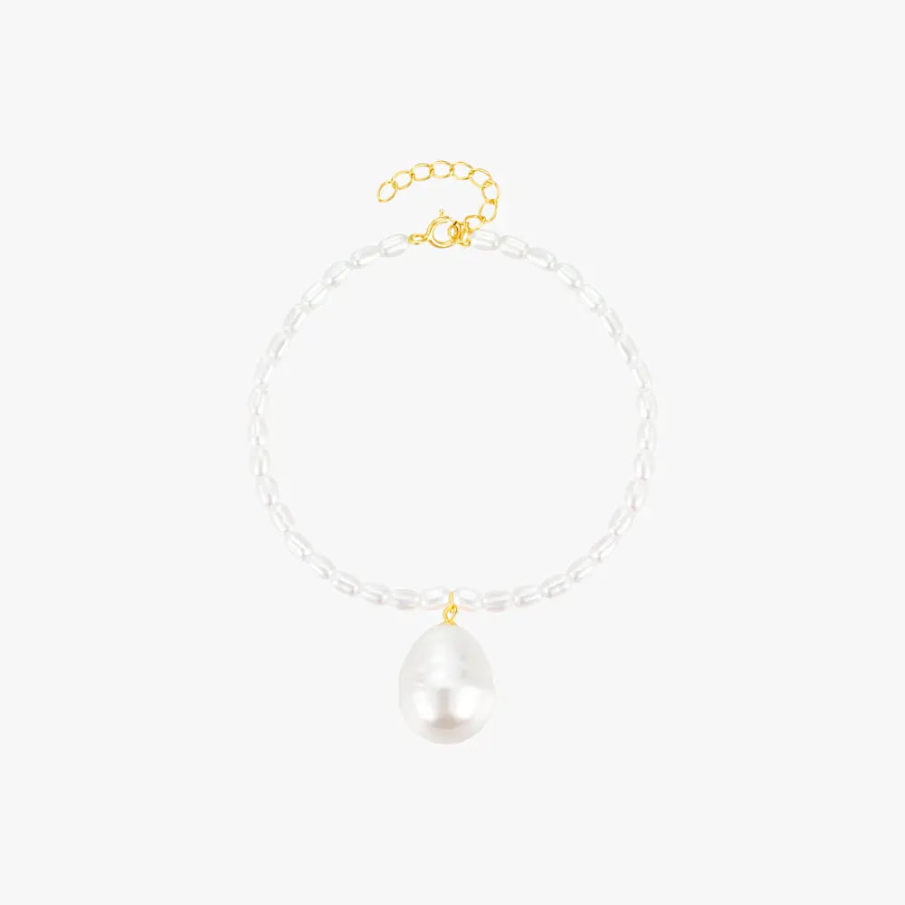 Minimalist pearl bracelet with a gold clasp and baroque pearl charm, adding sophistication to any outfit.