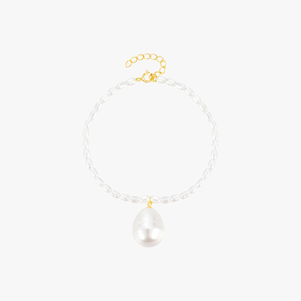 Minimalist pearl bracelet with a gold clasp and baroque pearl charm, adding sophistication to any outfit.