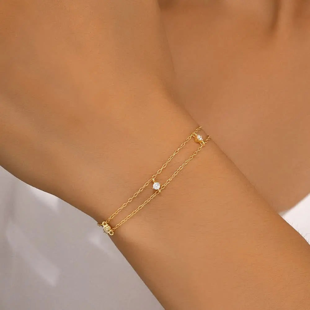 Simple gold bracelet with crystal accents, featuring a modern and minimal style.