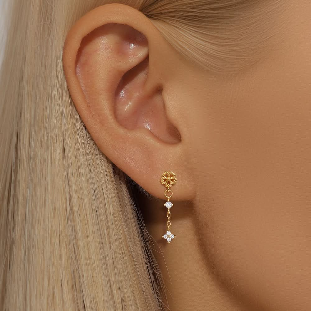 Triple star gold earrings with diamonds, worn by model, perfect for a trendy, sparkling look.